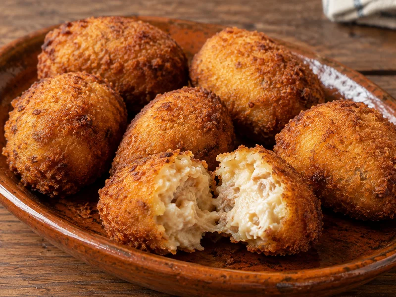 Croquetas caseras recién fritas, doradas y crujientes por fuera